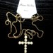 Aukso spalvos kaklo papuošalas su kryžium