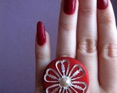 raudonas žiedas su gėle ir perliuku