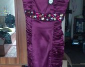 Proginė violetinės spalvos suknelė su papuošimais.
