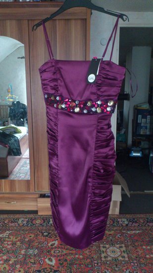 Proginė violetinės spalvos suknelė su papuošimais.