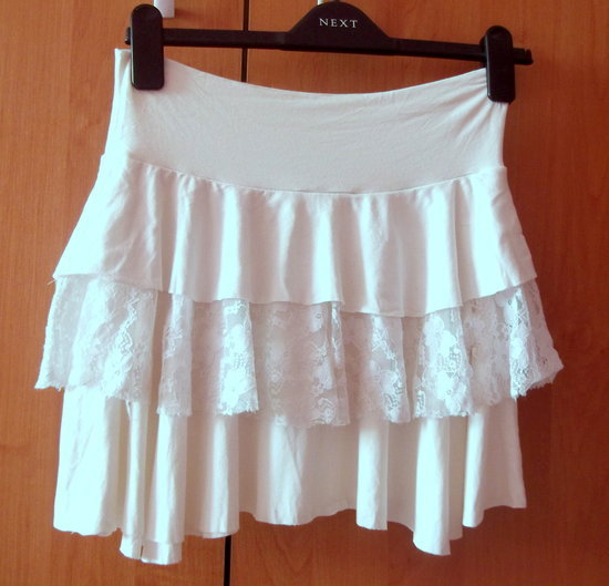 Baltas laisvai krentantis neriniuotas sijonas.